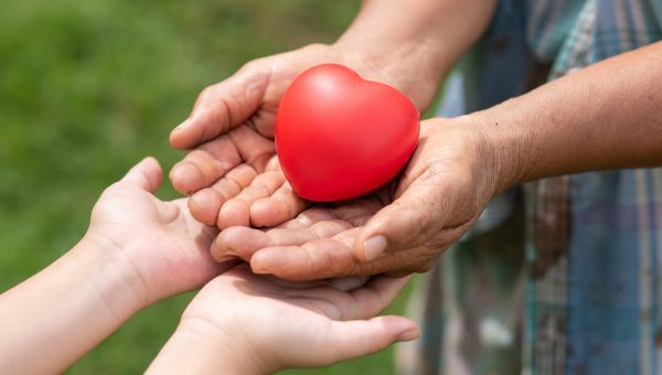 Mani che si intrecciano con un cuore al centro, simbolo di comunità e solidarietà