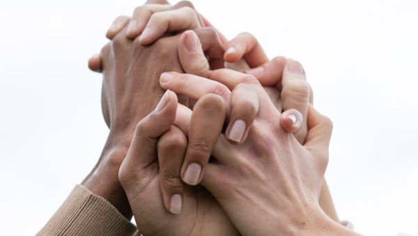 Mani incrociate in una situazione in cui si vive benessere psicologico e comunità unita